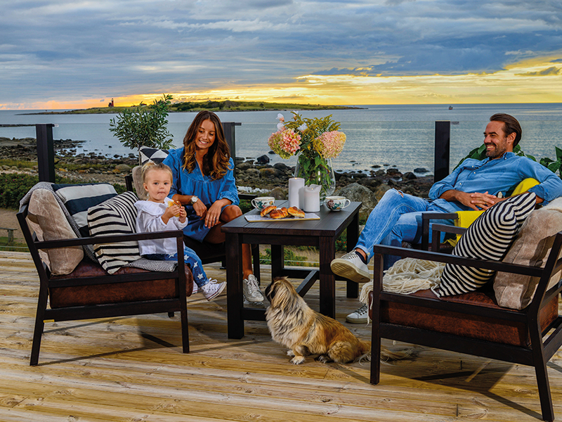 Familj sitter på sin terass i solnedgången